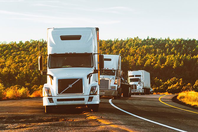 Three trucks on the road.