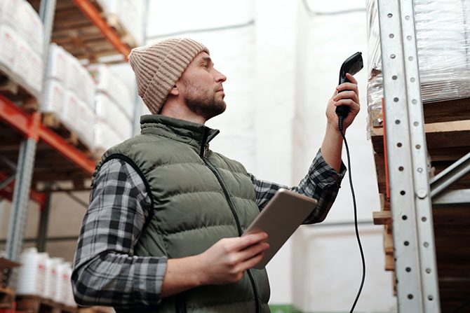 A worker checking shipping data, showing one of the best practices for transportation optimization