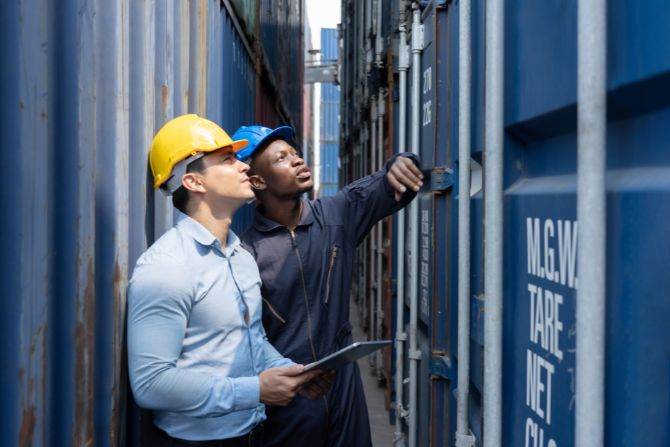 Logistics professionals inspecting a shipping container under EXW and DDP Incoterms
