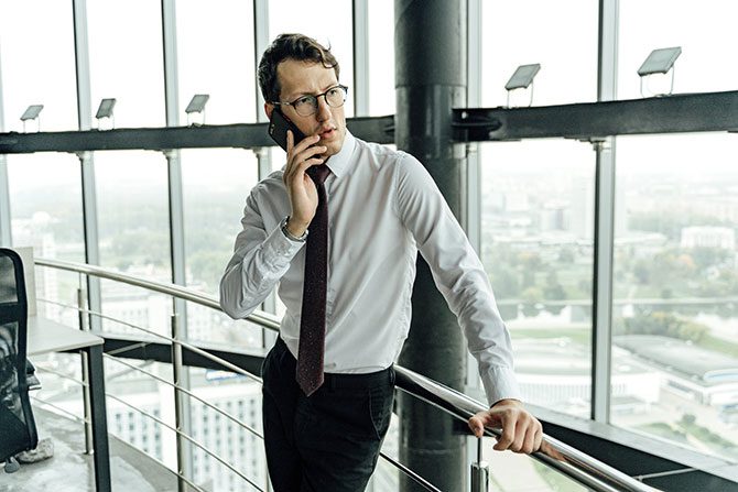 A person in business attire talking on a phone.