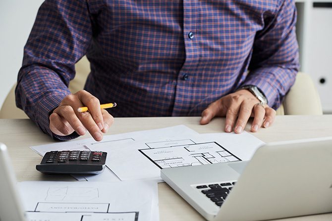 A man using a calculator for air freight cots