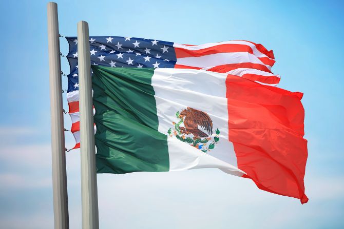 Flags of the United States and Mexico flying side by side, representing cross-border trade and partnership