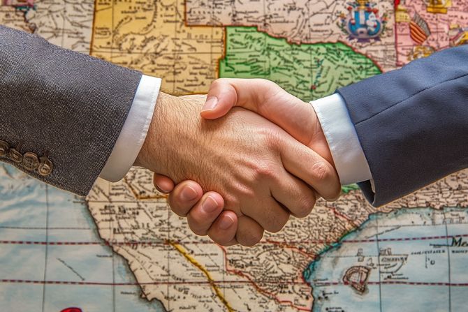 business handshake in front of a map, symbolizing cross-border logistics or international business partnership.