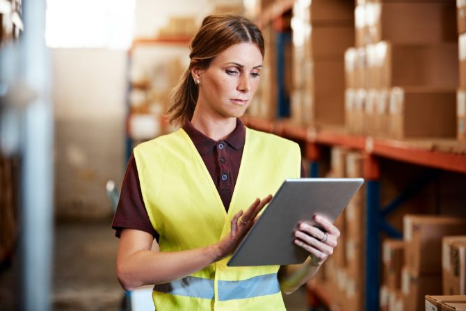 woman in a warehouse checking inventory.