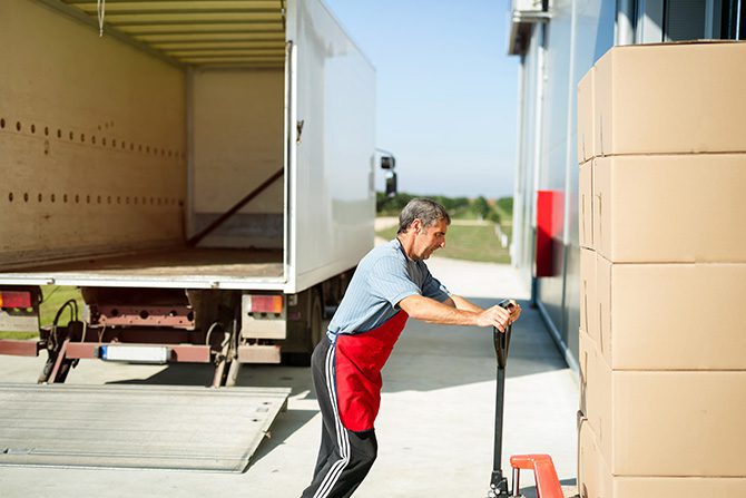 a man pushing boxes out of a truck